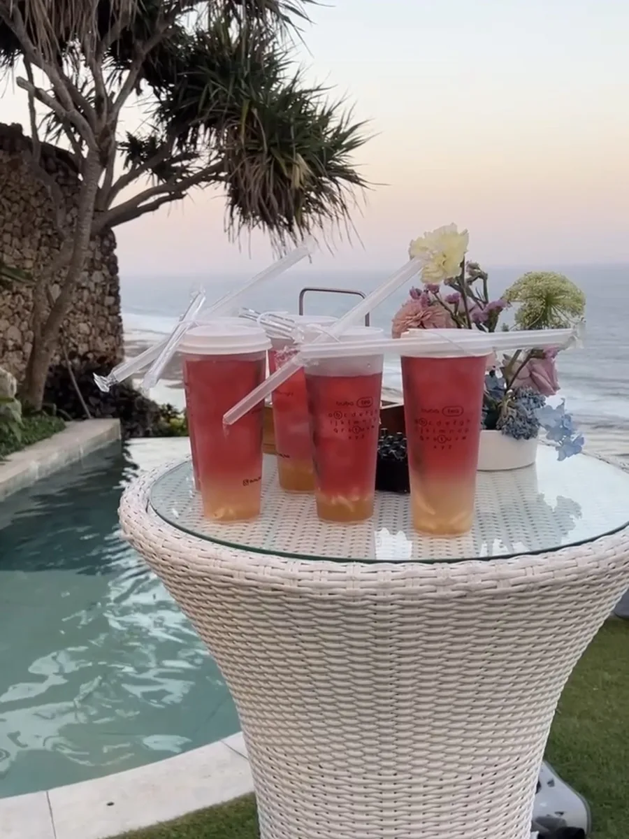 Iced teas on a table by the pool at sunset