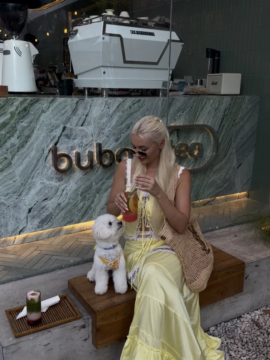 A guest with a drink at the green marble counter