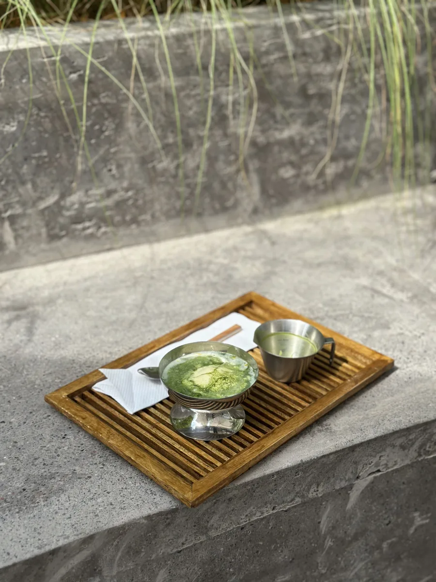 Matcha served on a wooden tray with a steel jug